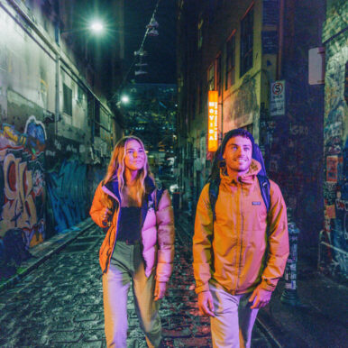 Couple at night in Melbourne graffiti alley.