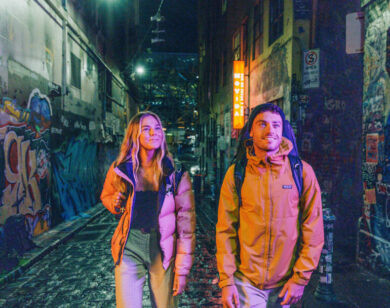 Couple at night in Melbourne graffiti alley.