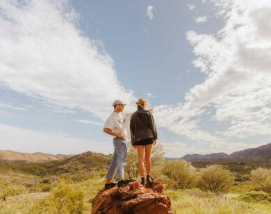 Couple on top of a rock column in the outback.