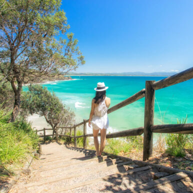 Photo of a young lady descending beach stairs.